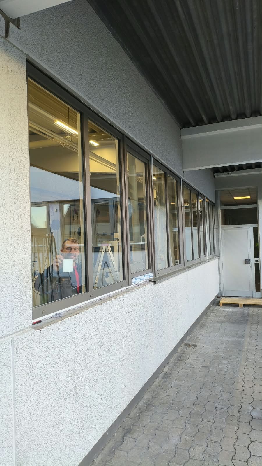 Lange Reihe neu eingebauter Fenster unter dem überdachten Durchgang eines Gebäudes in Bielefeld