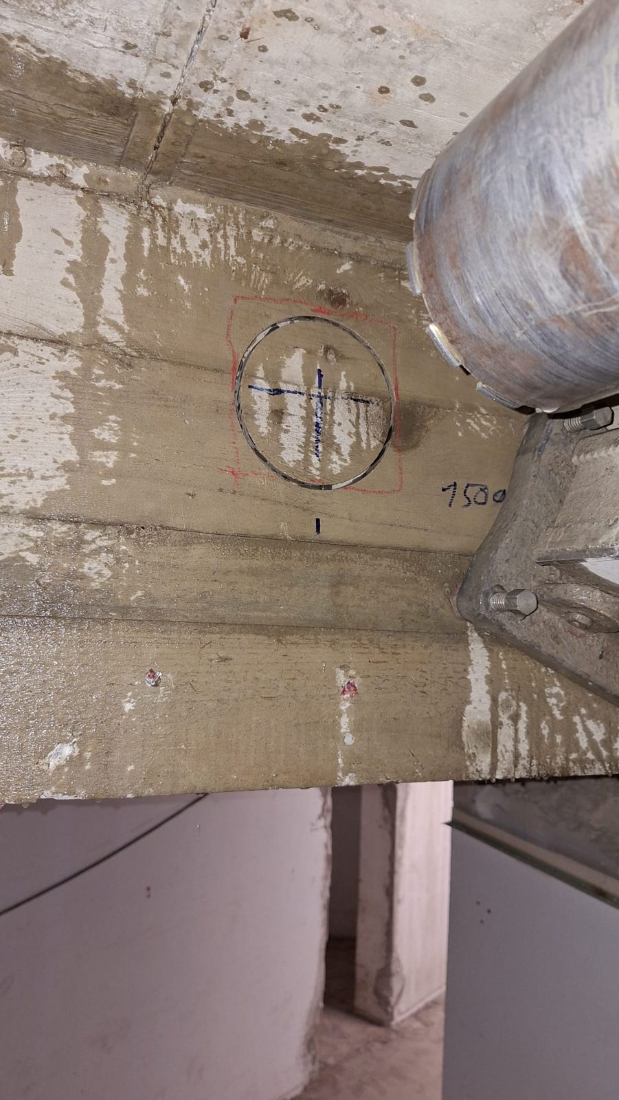 Markierte Kernbohrung mit 150 mm Durchmesser in der Betondecke, daneben die Bohrkrone